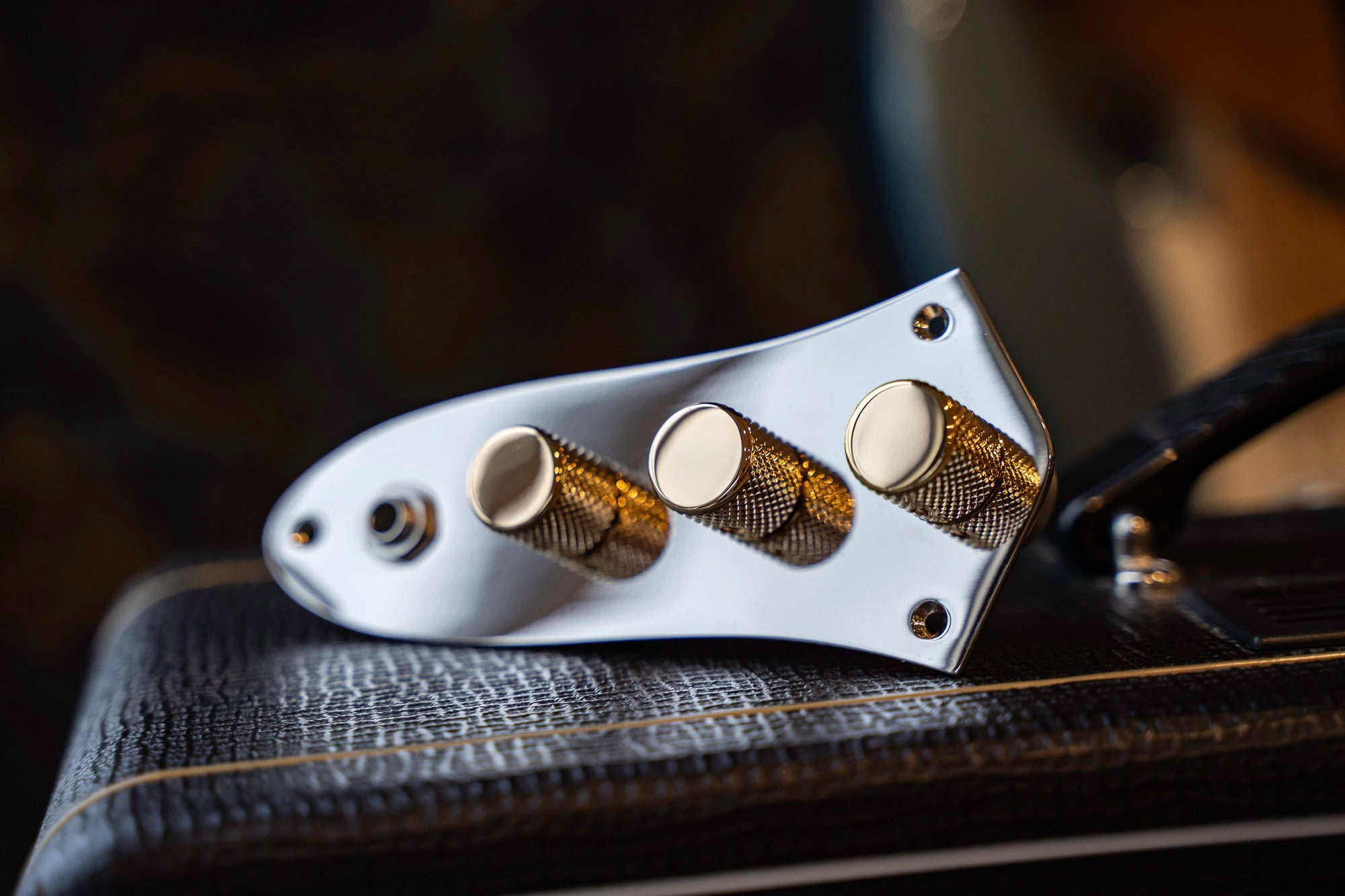 The image shows four loaded control plates for telecaster lined up. Each loaded control plate id finished in a different color with, black, gold, chrome and nickel.