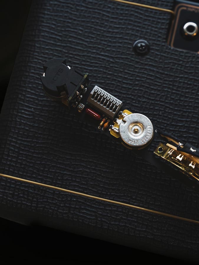 a set of ObsidianWire pro-wired electronics on top of a black Vox AC10 guitar amp.